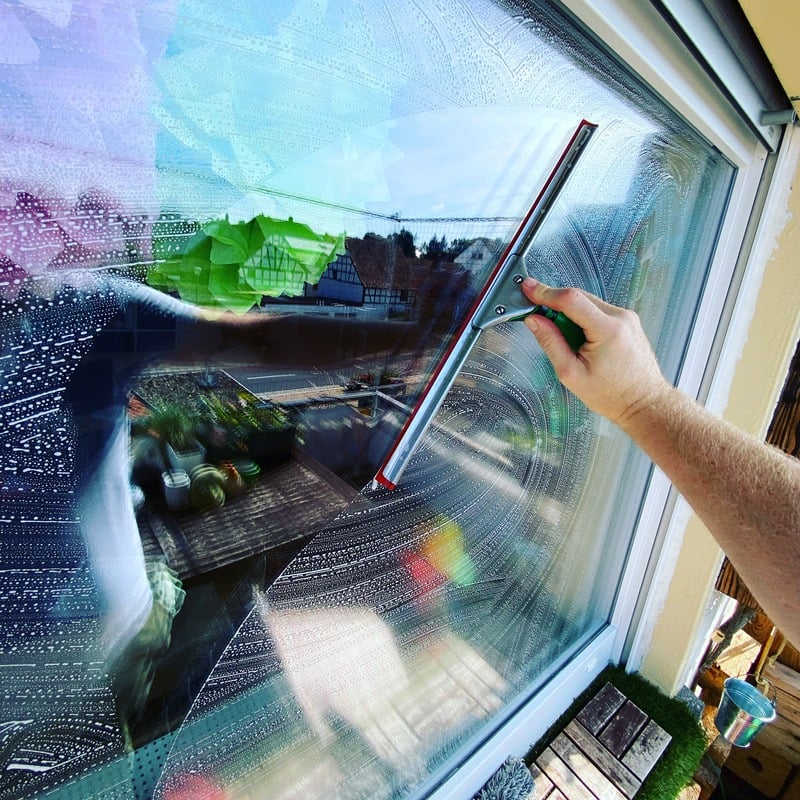 Professionelle Fensterreinigung - Silhouette eines Fensterputzers bei der Arbeit